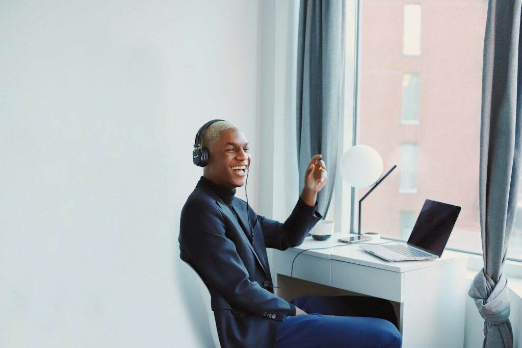 Smiling man wearing a headset in a video meeting on his laptop